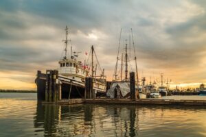 Fishing Boats in Steveston Harbour, Richmond, BC, Canada at sunset covered by cloudy skies.