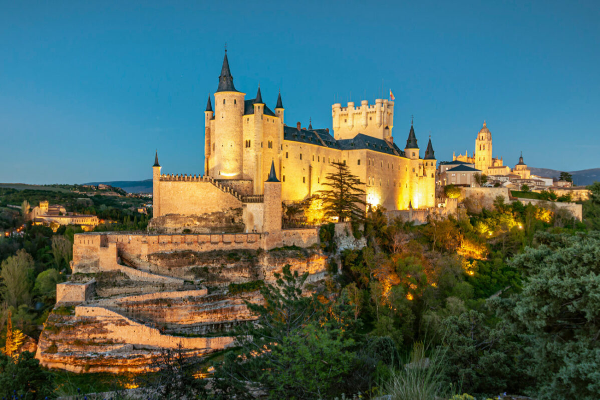 Warm sunset light on Alcázar de Segovia castle landscape seen from Mirador del Alcázar viewpoint in Spain.
